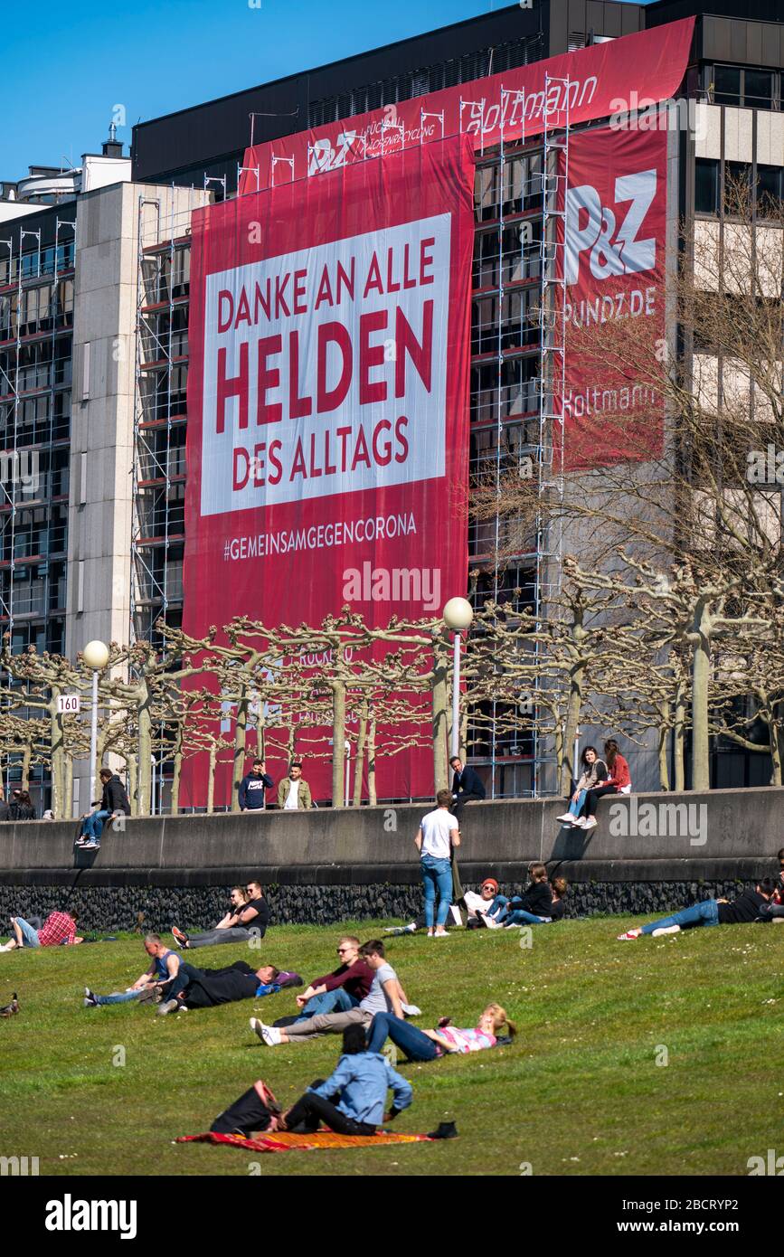 An der Rheinpromenade hat eine Baufirma ein großes Plakat mit den Helden des Alltags an der Fassade eines Hauses, DŸsseldor, aufgehängt Stockfoto