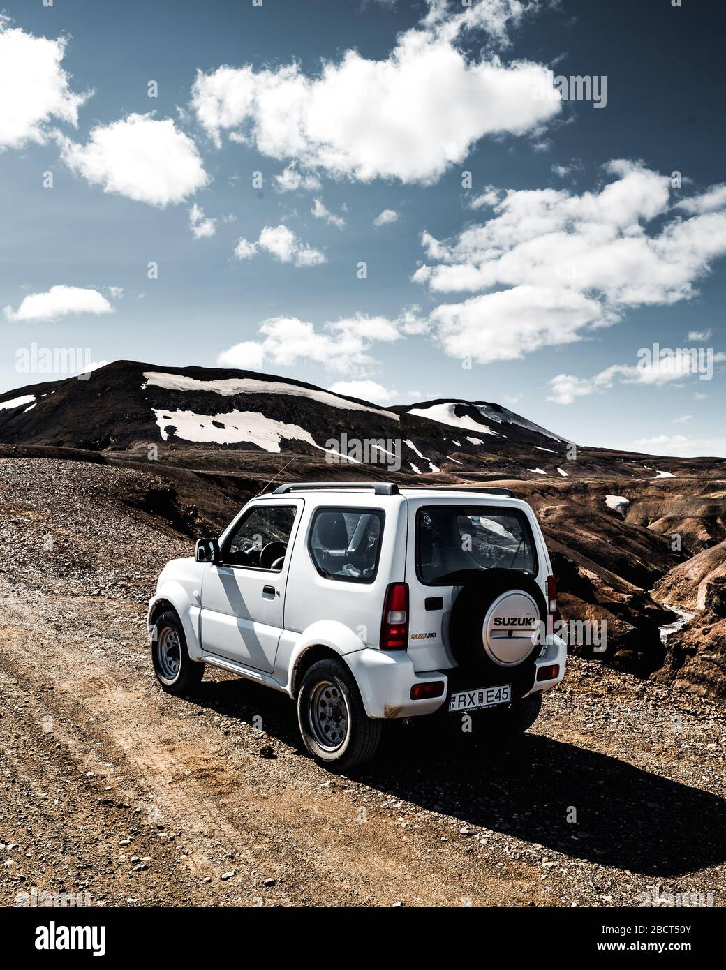 Kerlingarjfoll, Island. Allradantrieb Jeep Suzuki Jimny ist auf der Straße in der hellen Sonne Blendung und Reflexionen. Kerlingarjföll im Rücken Stockfoto