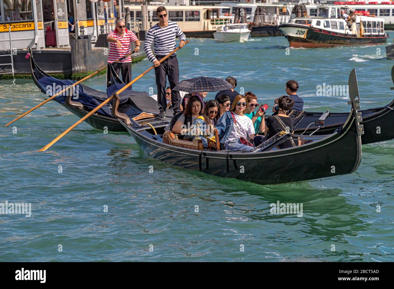 Eine Gruppe chinesischer Touristen, die eine Gondelfahrt auf dem Canal Grande in Venedig, Italien, machen Stockfoto