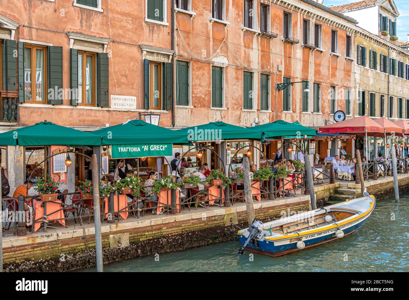 Leute, die außerhalb der Trattoria da Giorgio Al Greci essen, ein italienisches Restaurant am Kanal auf Fondamenta S. Lorenzo, Venedig, Italien Stockfoto