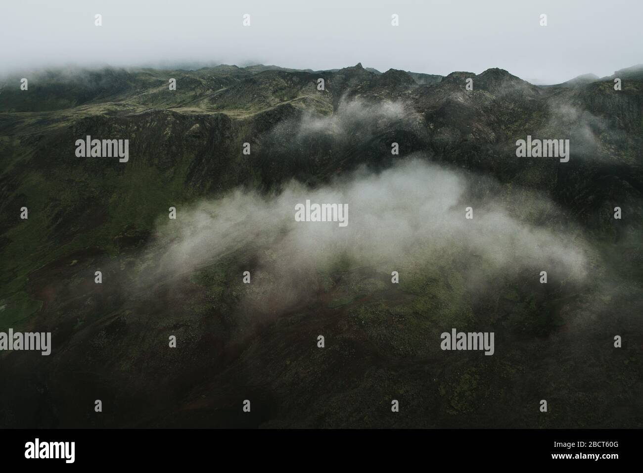 Drohnenansicht eines Berges über den Wolken an einem nebligen Tag, Island. Stockfoto
