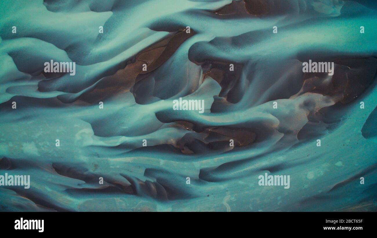 Vogelperspektive von oben auf einem grünen und blauen Gletscherfluss in Südisland. Schöne Muster, Texturen und Strukturen. Schmelzender Gletscher. Stockfoto