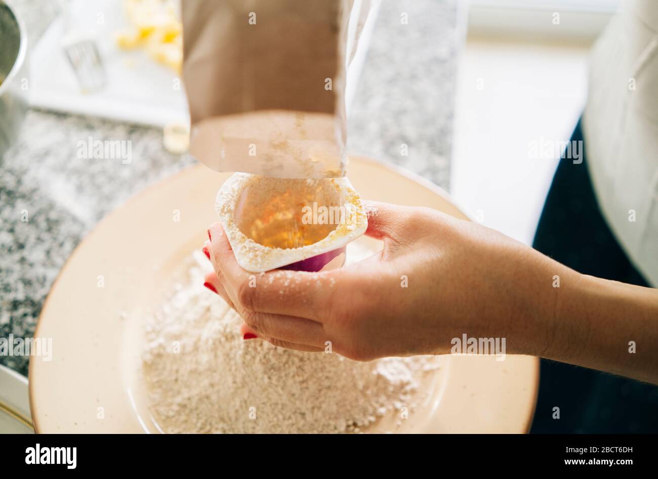 Frau bereitet die Zutaten für einen Biskuitkuchen vor Stockfoto