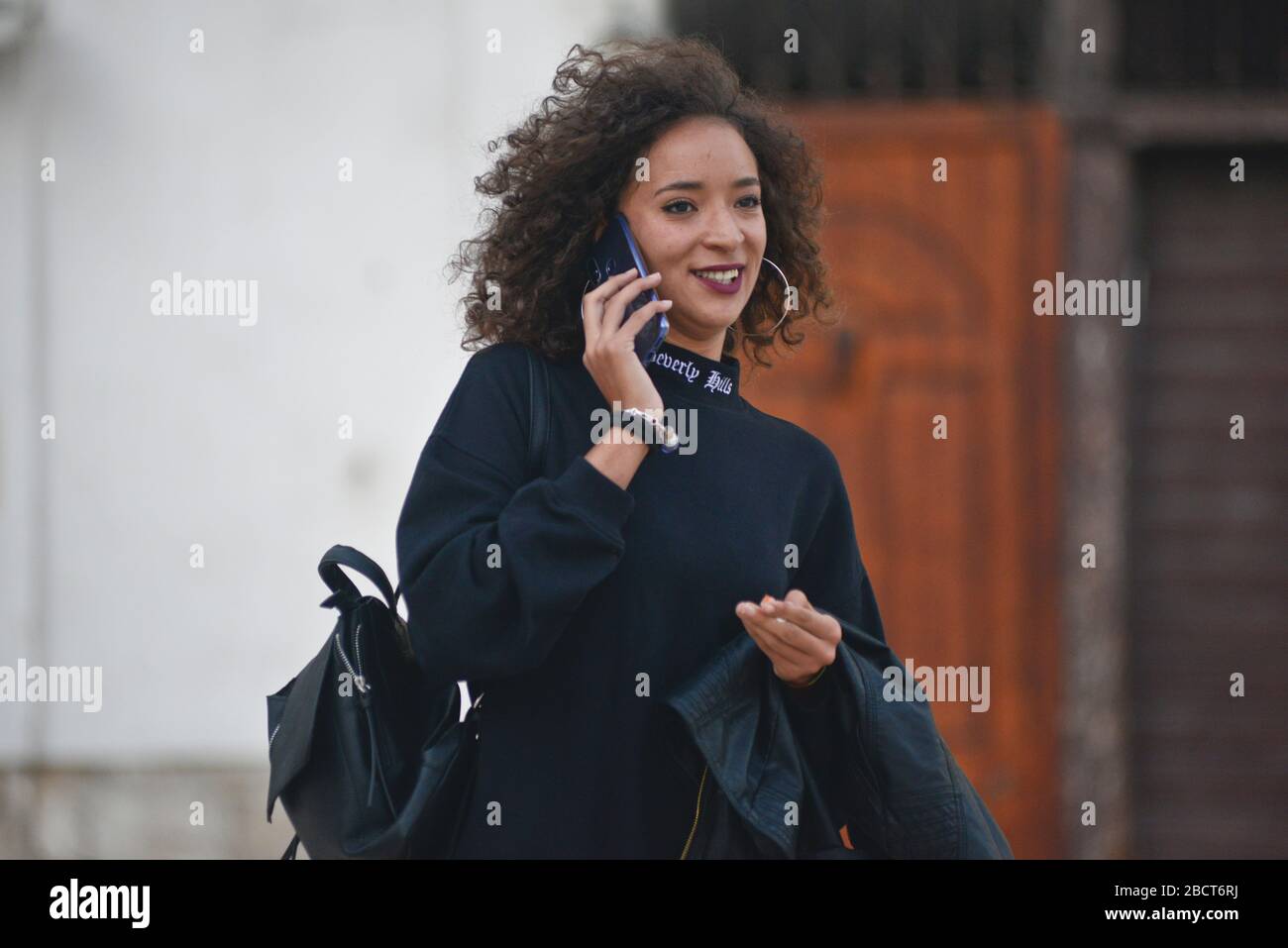 Ein schwarzes Mädchen, das am Telefon auf der Piazza Mercantile, Bari, Italien spricht Stockfoto