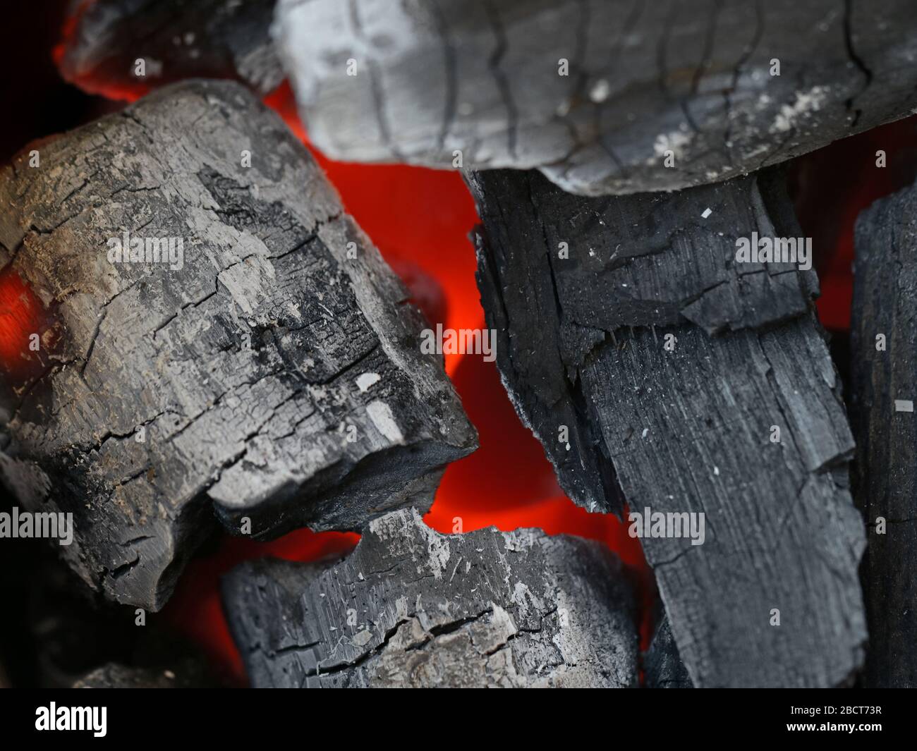 Nahaufnahme glühender Kohlen in einem Grillgrill, Holzkohlehintergrund Stockfoto