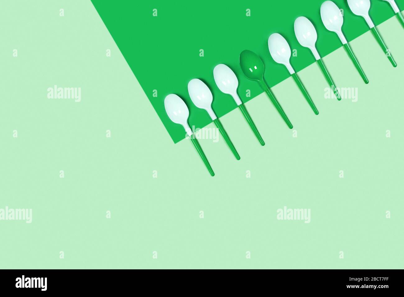 Abbildung der weißen Kunststofflöffel auf blauem Hintergrund. Flaches Layout, Draufsicht, Kopierbereich. Stockfoto