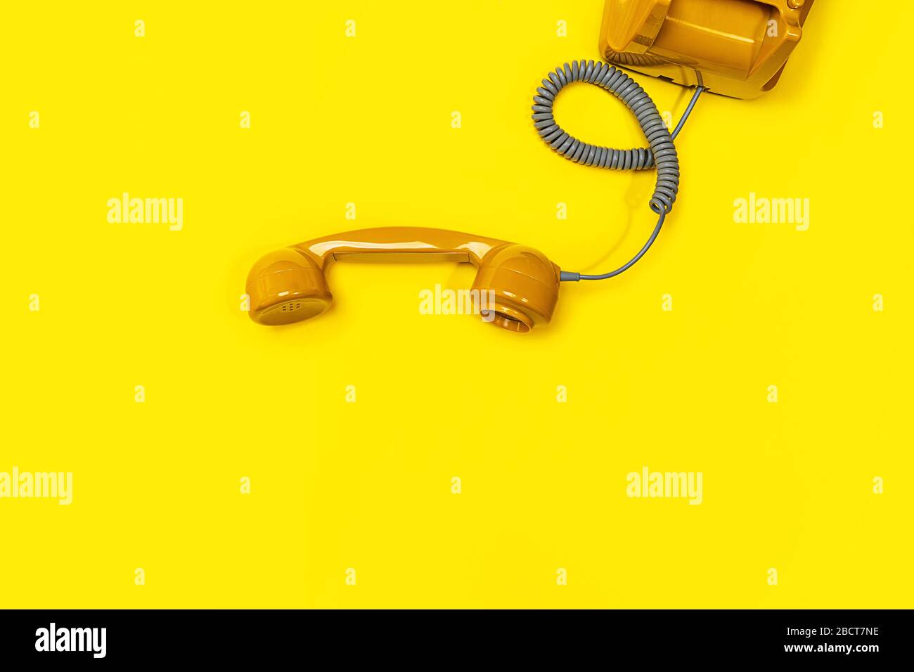 Altmodisches Mobilteil auf gelbem Hintergrund. Modernes Rotationstelefon im Retro-Stil. Neue alte Technologie. Stockfoto
