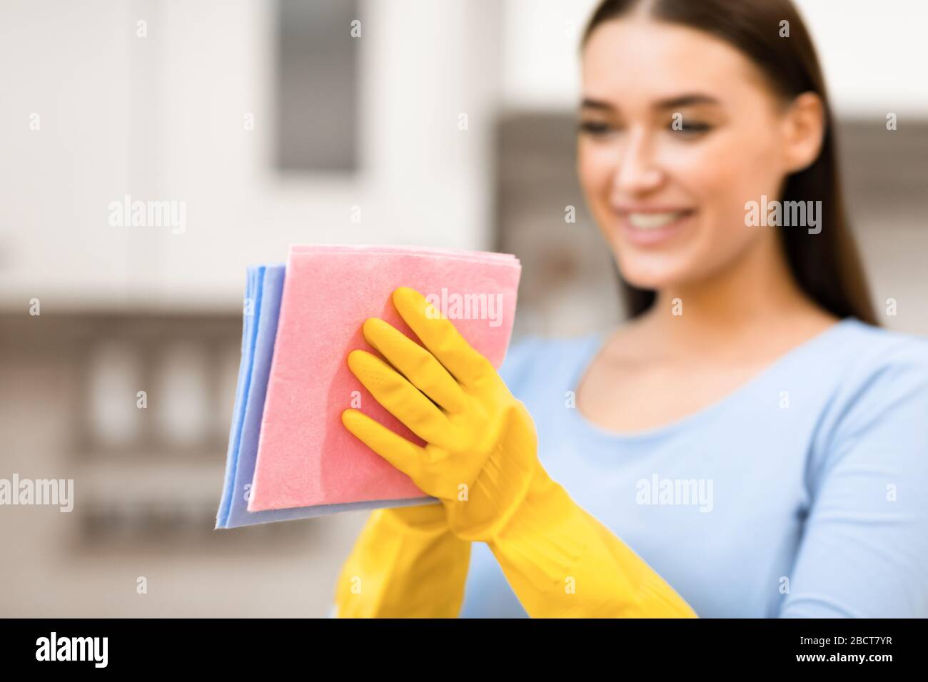 Junge Frau, die Lappen zur Reinigung der Küche hält Stockfoto