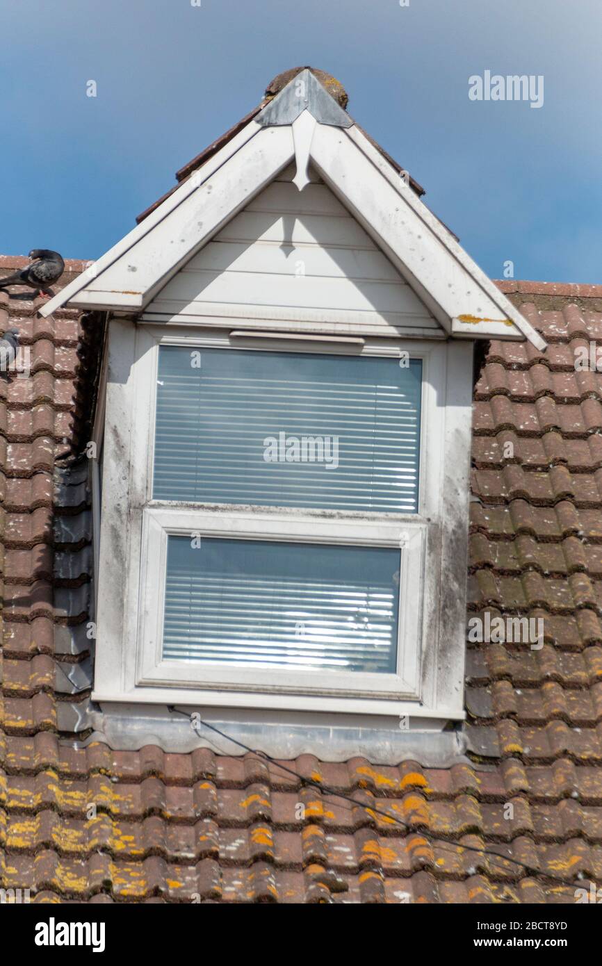 Nahansicht eines kleinen Fensters oben auf einem Dachbereich Stockfoto