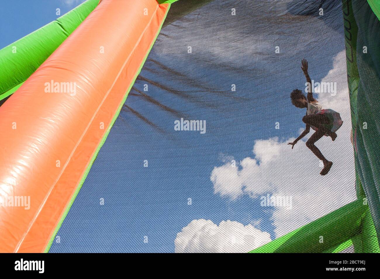 Ein nicht identifiziertes Mädchen springt auf einem riesigen Schlauchboot am Fun Day at the Park am 10. August 2019 in Atlanta, GA, aus zweistöckiger Höhe in eine Plastikgrube. Stockfoto