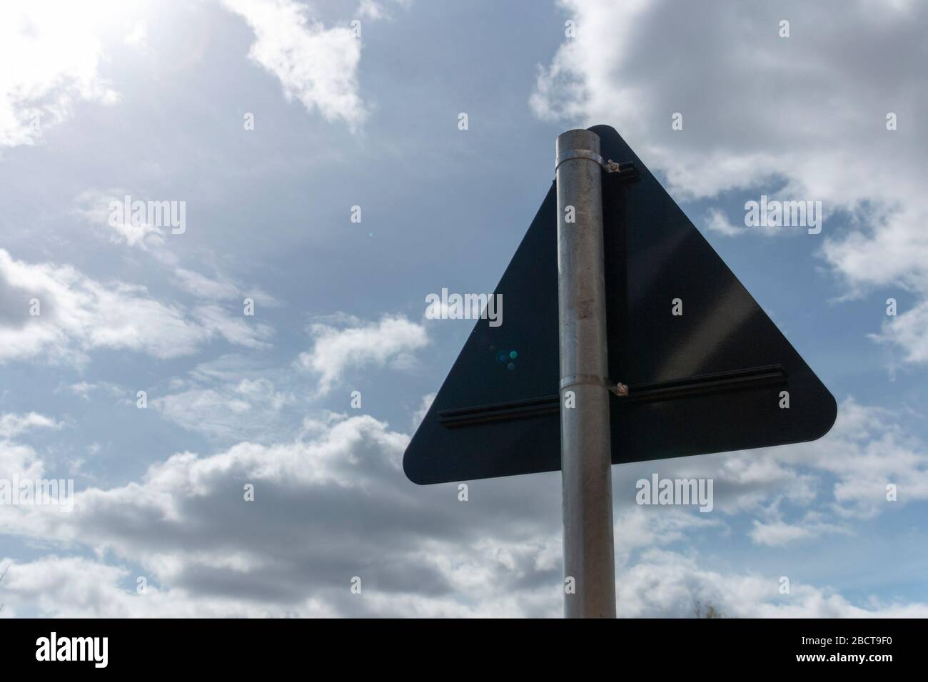 Eine Nahansicht der Rückseite eines Metallschildes mit dem leuchtend blauen Himmel im Hintergrund Stockfoto