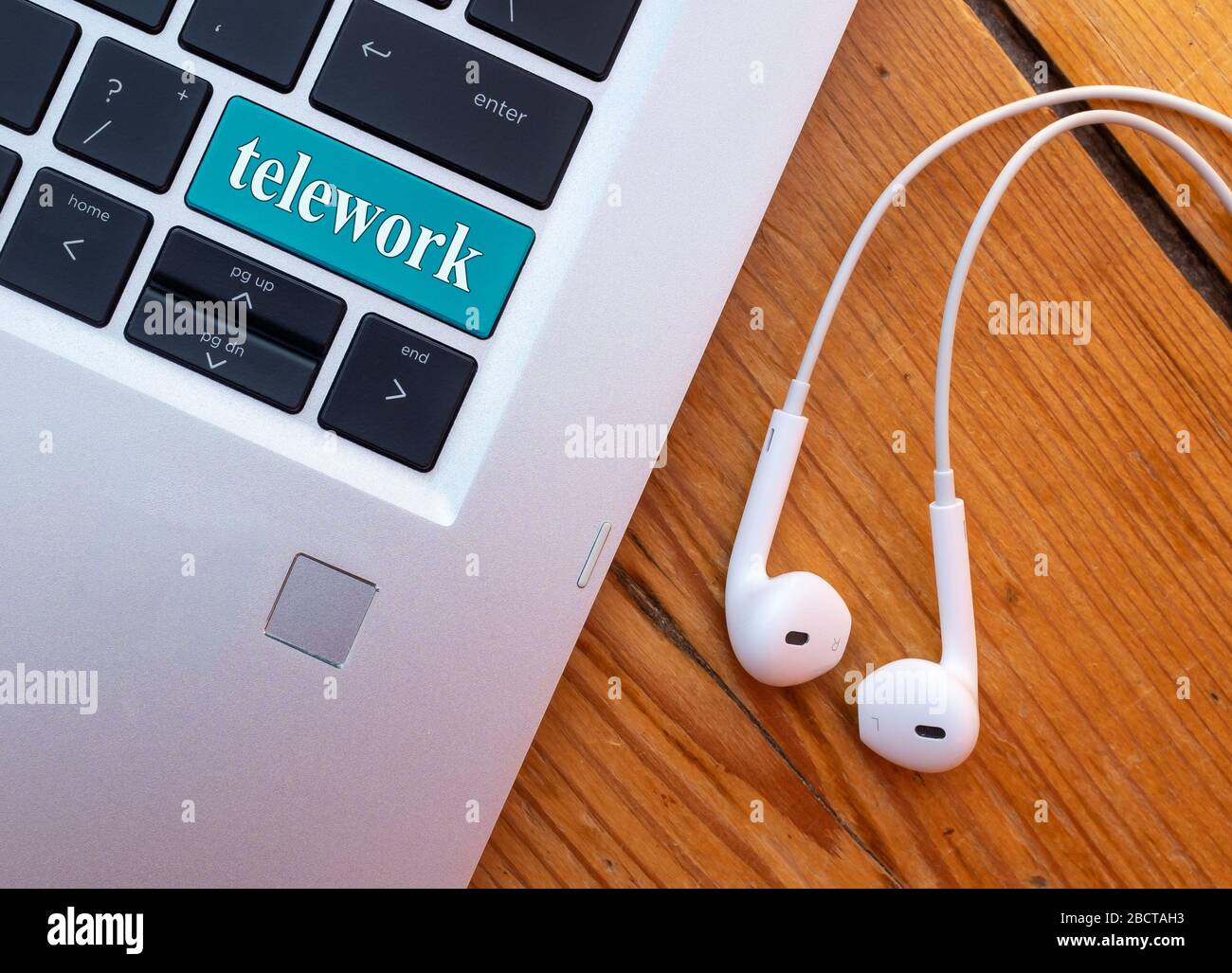 Telearbeit-Konzept. Laptop mit Headset und Wort-Telearbeit auf der Tastatur. Stockfoto