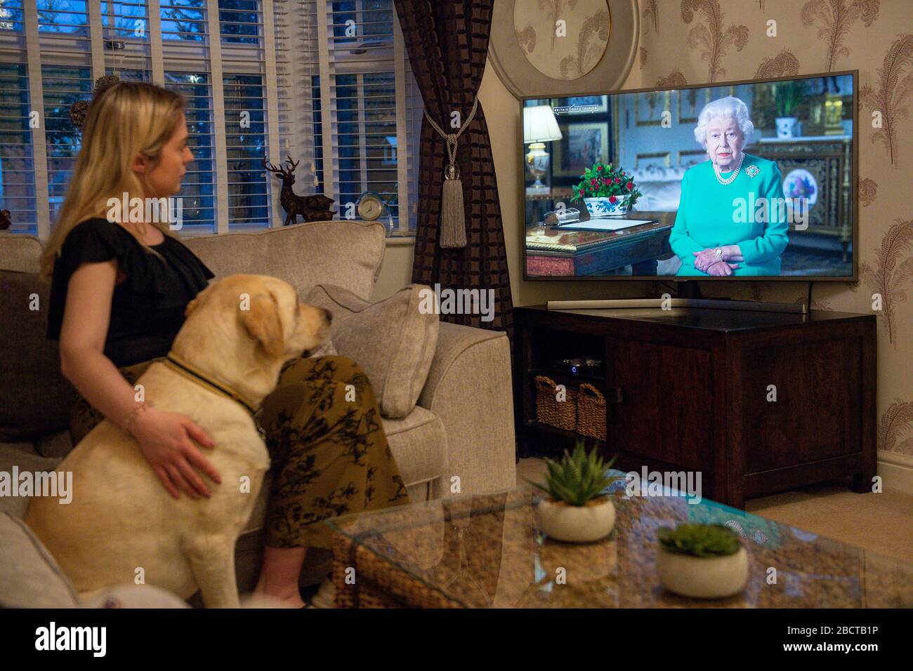 Die Familie Doyle im Dorf von Bishop's Itchington in Warwickshire beobachtet, wie Königin Elizabeth II. Ihre Ansprache gegenüber der Nation und dem Commonwealth in Bezug auf die Coronavirus-Epidemie überbringt. Stockfoto