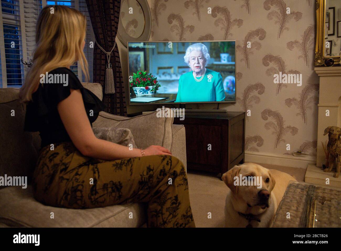 Die Familie Doyle im Dorf von Bishop's Itchington in Warwickshire beobachtet, wie Königin Elizabeth II. Ihre Ansprache gegenüber der Nation und dem Commonwealth in Bezug auf die Coronavirus-Epidemie überbringt. Stockfoto