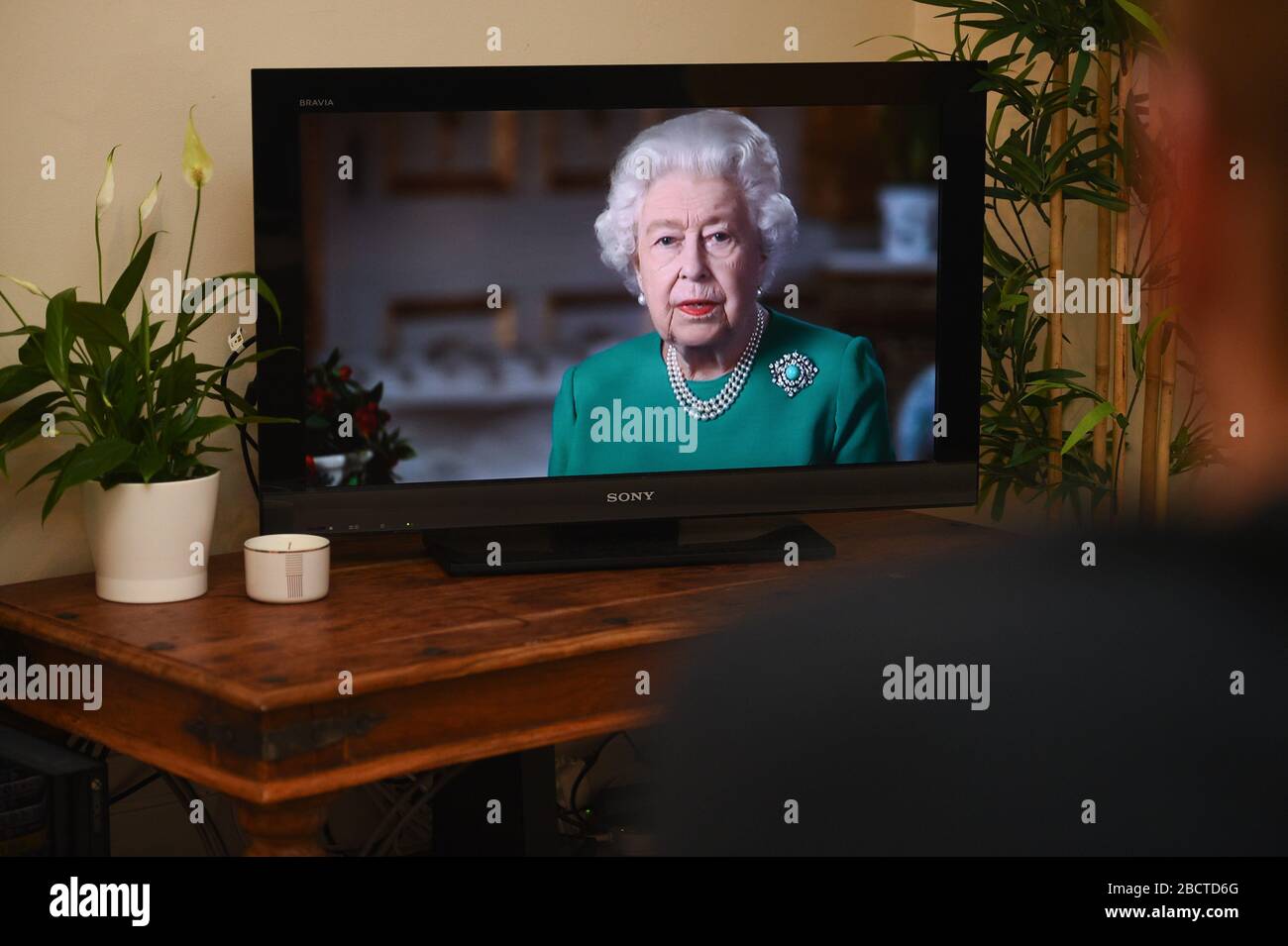 Die Menschen in Wandsworth, London, beobachten, wie Königin Elizabeth II. Ihre Ansprache gegenüber der Nation und dem Commonwealth im Zusammenhang mit der Coronavirus-Epidemie überbringt. Stockfoto