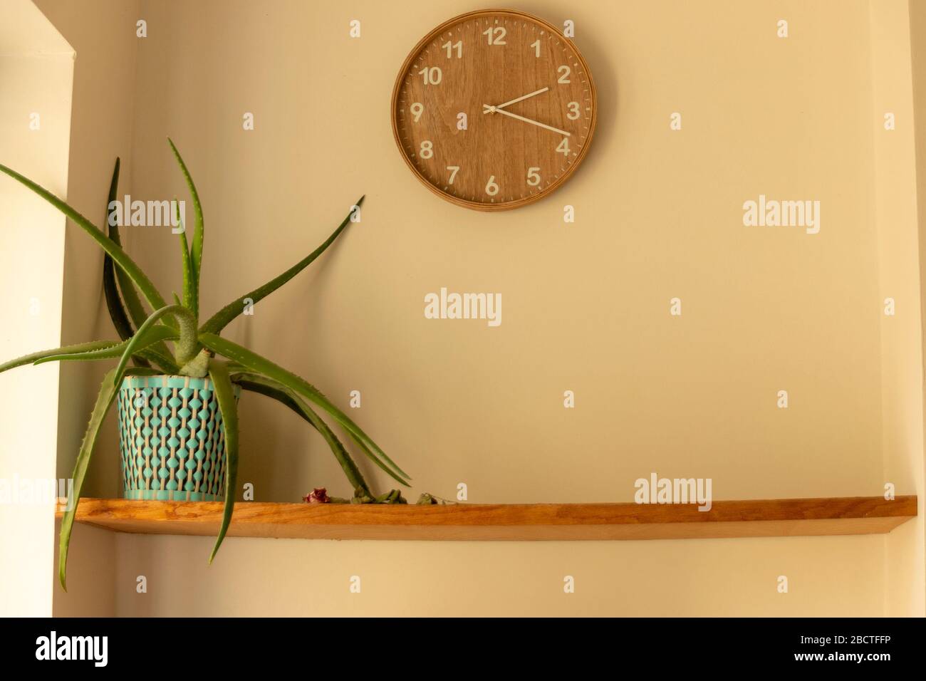 Nahansicht einer Uhr an der Wand mit einer Anlage im ersten Regal Stockfoto