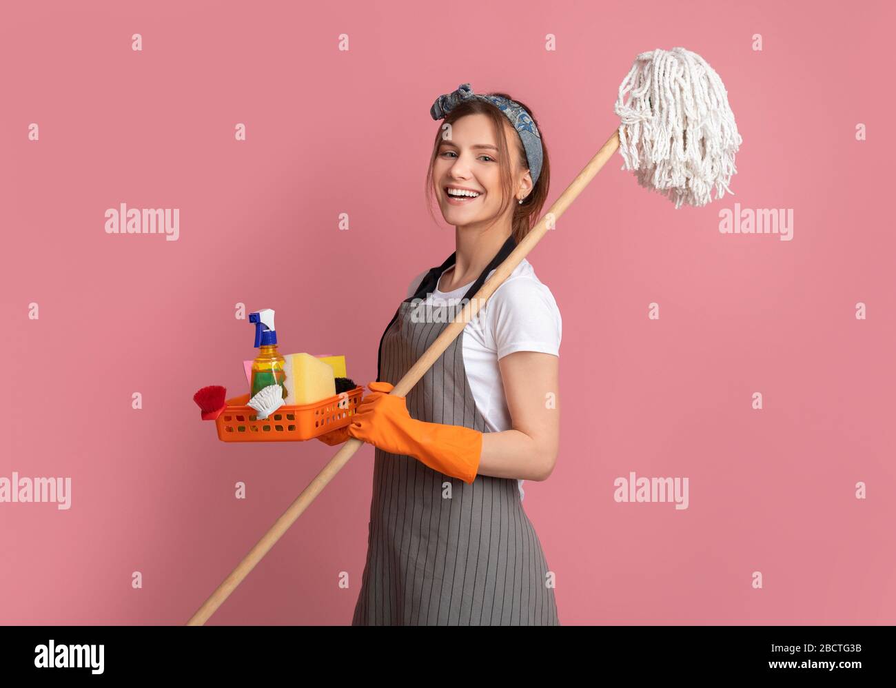 Professionelle Reinigung. Lächelnde Junge Frau Mit Haushaltsbedarf In Den Händen Stockfoto