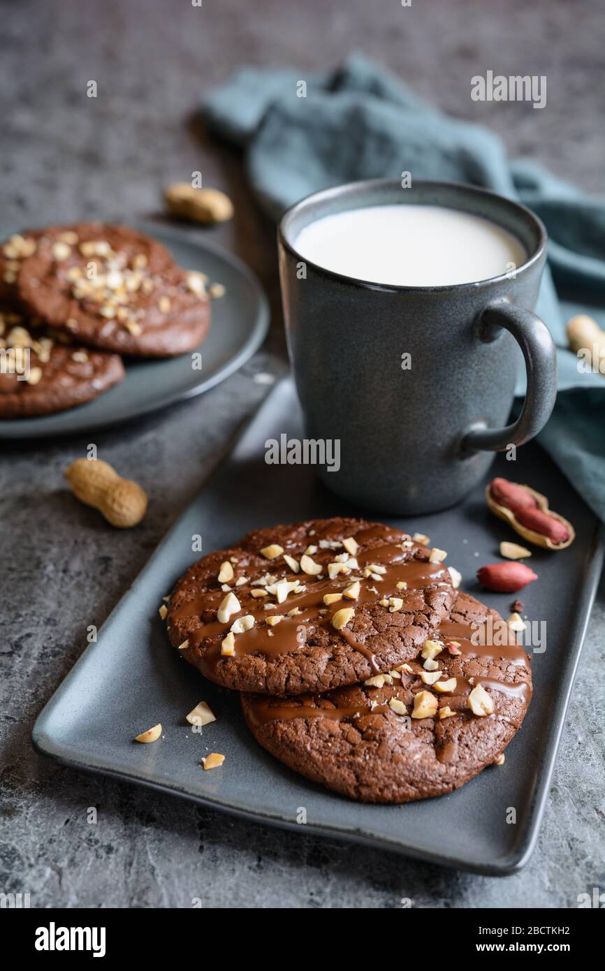 Köstliche Brownie-Plätzchen mit geschmolzener Schokolade und gehackten Erdnüssen Stockfoto