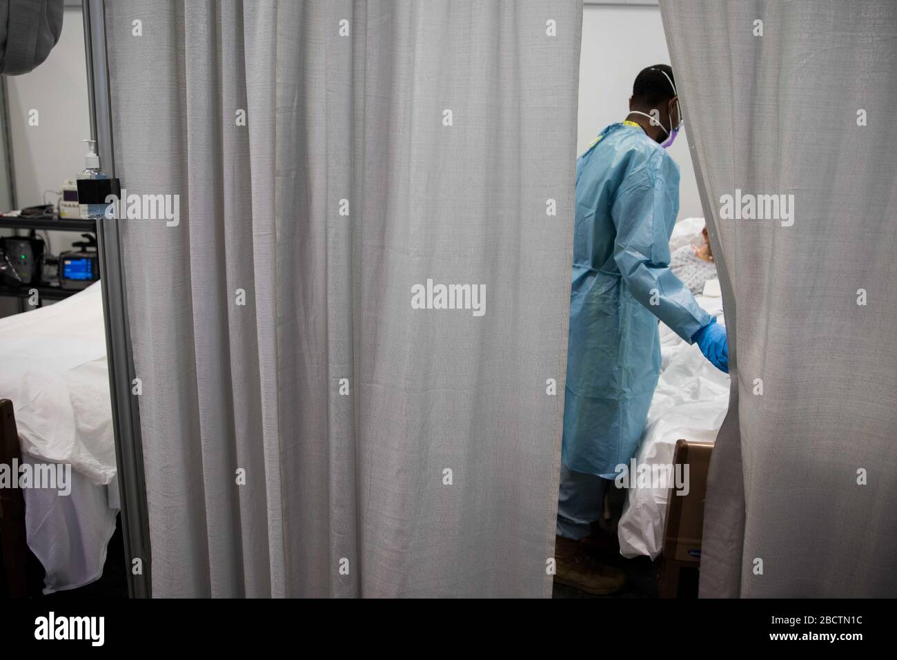 Ein US-Arzt prüft einen Patienten auf der Intensivstation auf COVID-19, eine pandemische Linderung des Coronavirus im Jacob Javits Center am 4. April 2020 in New York City, New York. Stockfoto