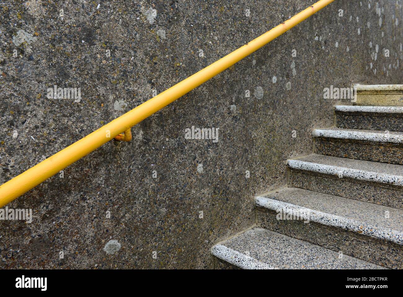 Betonstufen und gelbe Geländer auf der Fußgängerbrücke am Bahnhof Southease, Sussex, Großbritannien Stockfoto