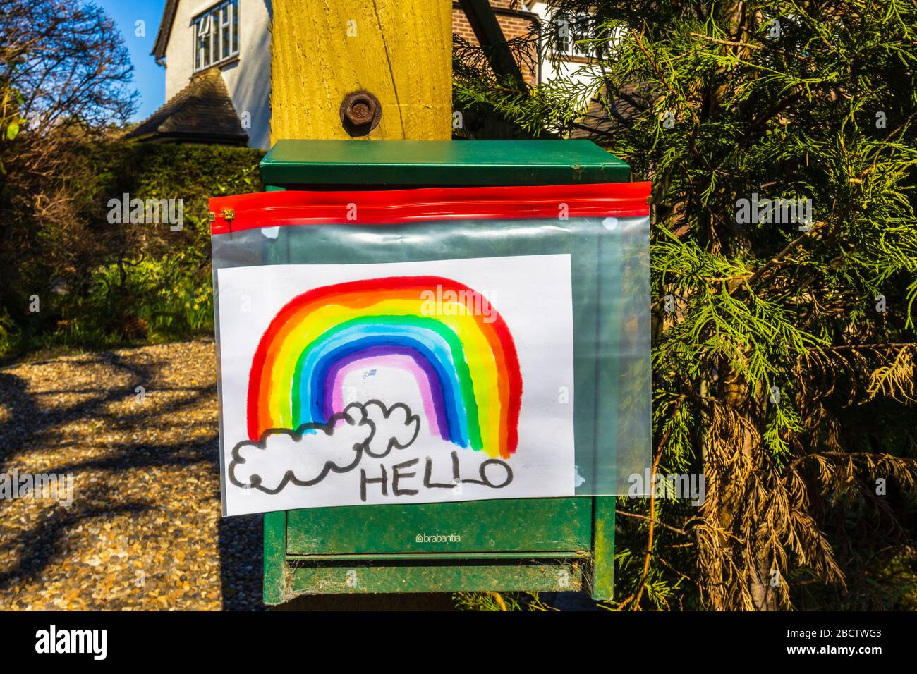 Das Bild eines Kindes von einem Regenbogen in einer Woking-Straße, während Menschen versuchen, sich während des Ausbruchs des Coronavirus und des Lockdowns positiv isoliert in ihren Häusern aufzuhalten Stockfoto