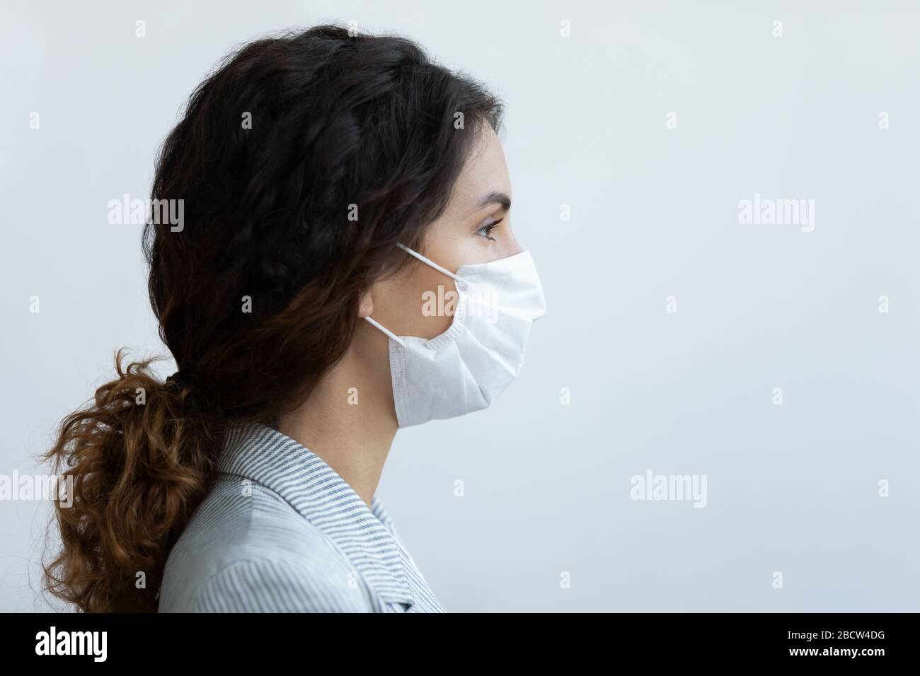 Dame mit ärztlicher Atemschutzmaske, die nach Text auf dem Kopierraum sucht. Stockfoto