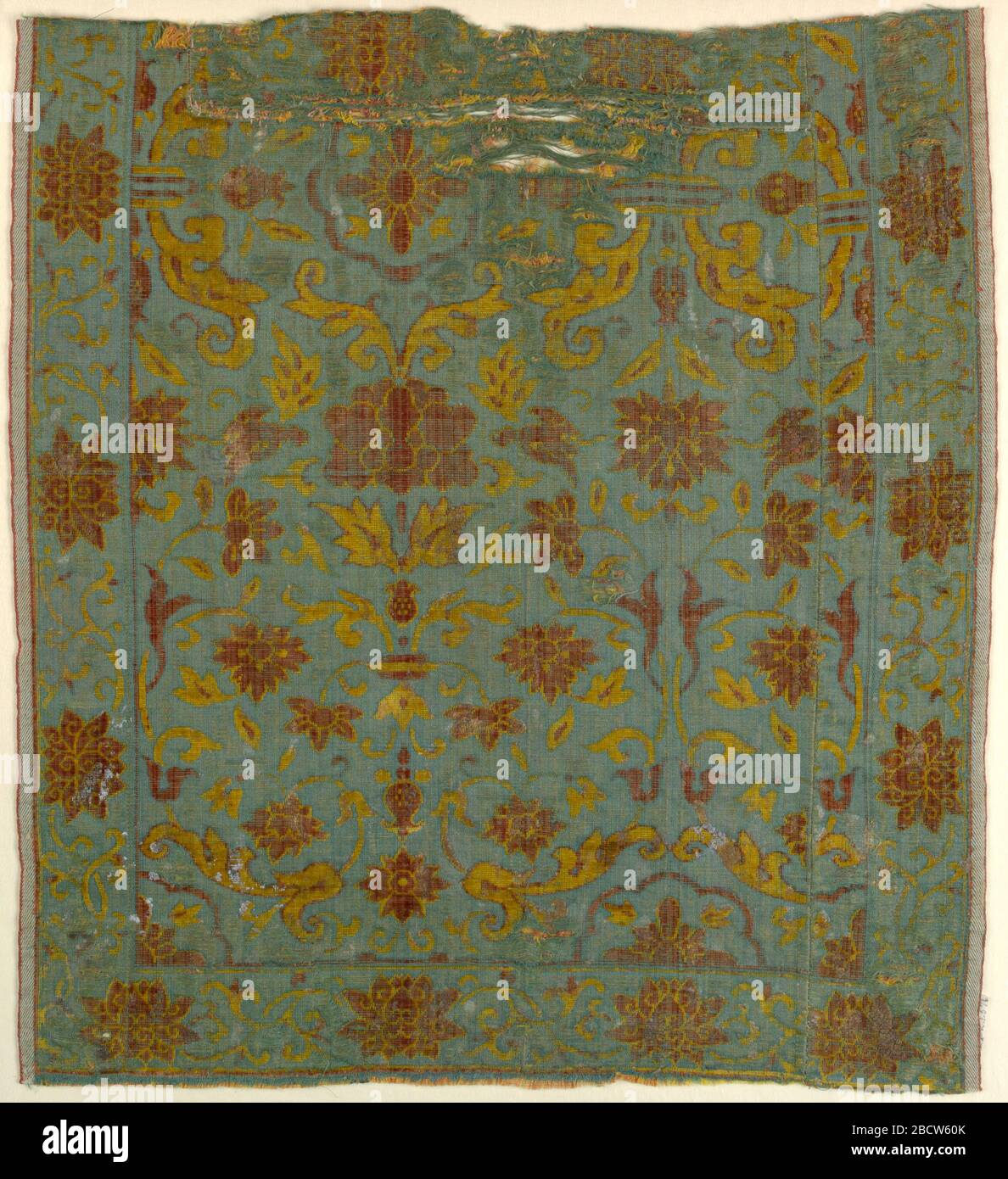 Fragment. Forschung in ProgressYellow und braunen Blumen- und Bildlaufmotiven auf blauem Hintergrund.Selvage auf beiden Seiten, aber das Stück ist in der Mitte gesät. Fragment Stockfoto