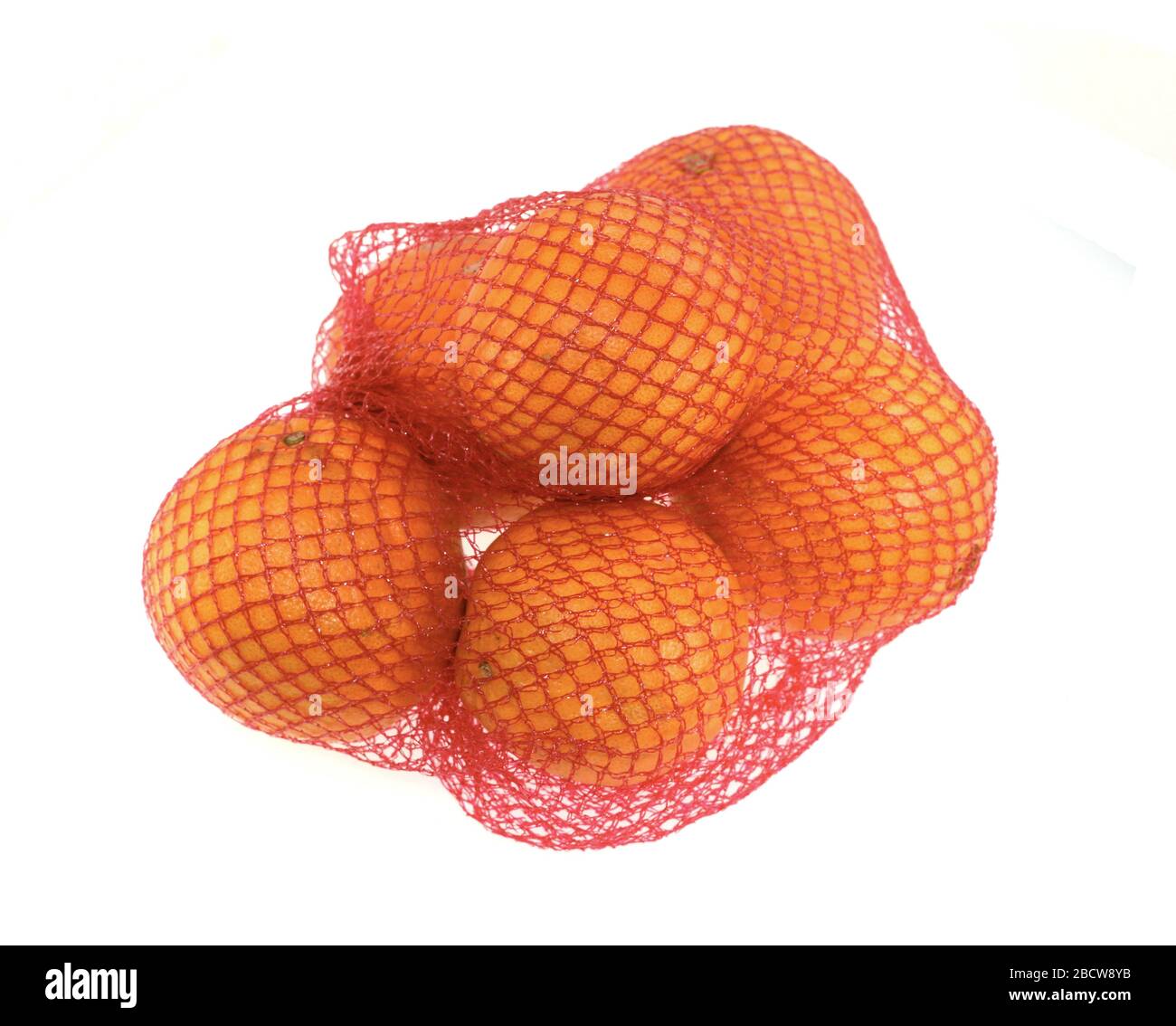 Orange im roten Netz isoliert auf weißem Hintergrund. Frische Orangen in Kunststoff-Mesh-Sack. Stockfoto