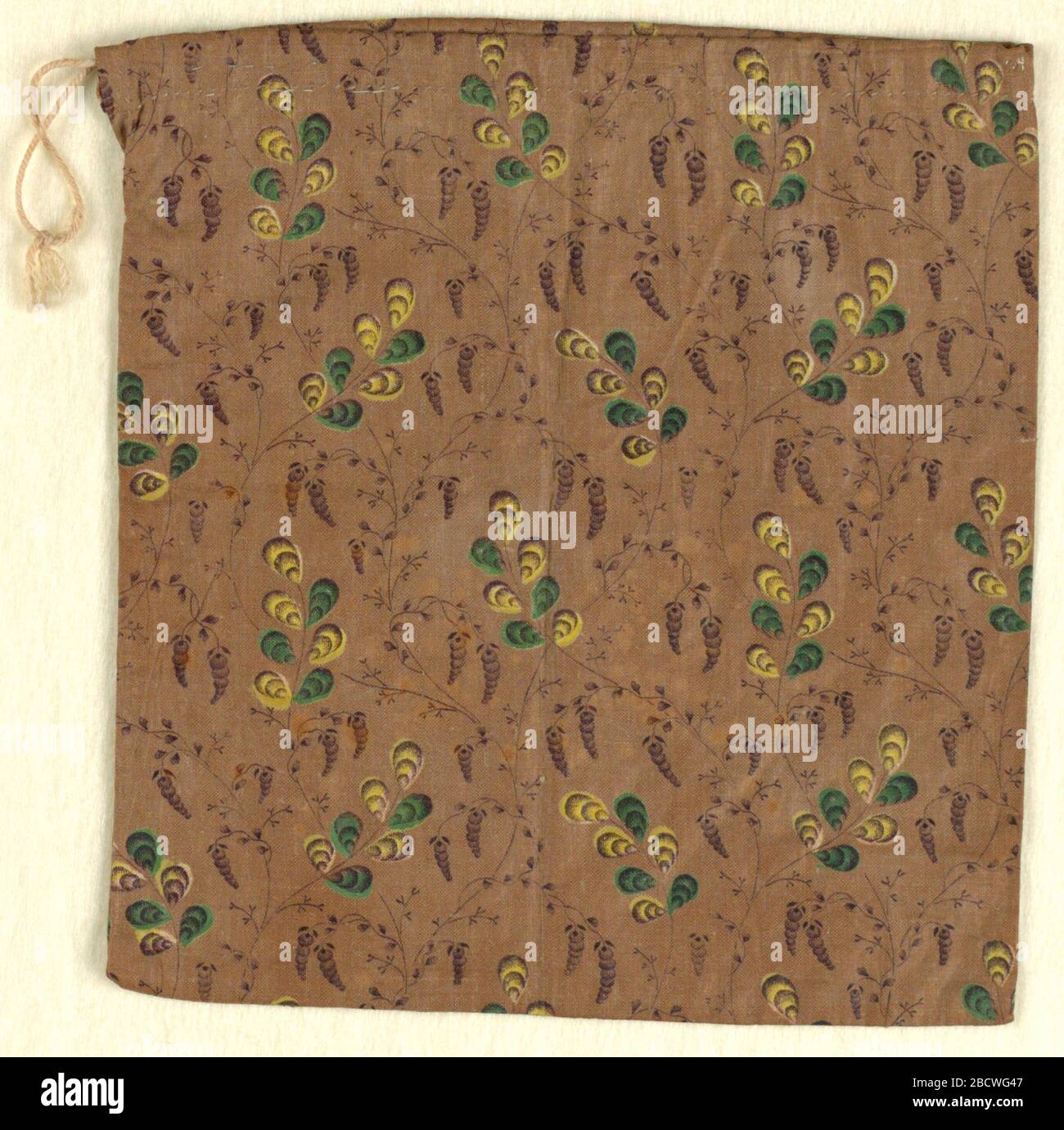 Tasche. Forschung in ProgressPlain, quadratischer Calico-Tasche; Design von Blattwerk und Blumen in Gelb, Grün und Dunkelbraun auf hellbraunem Boden. Kordelzug oben. Tasche Stockfoto