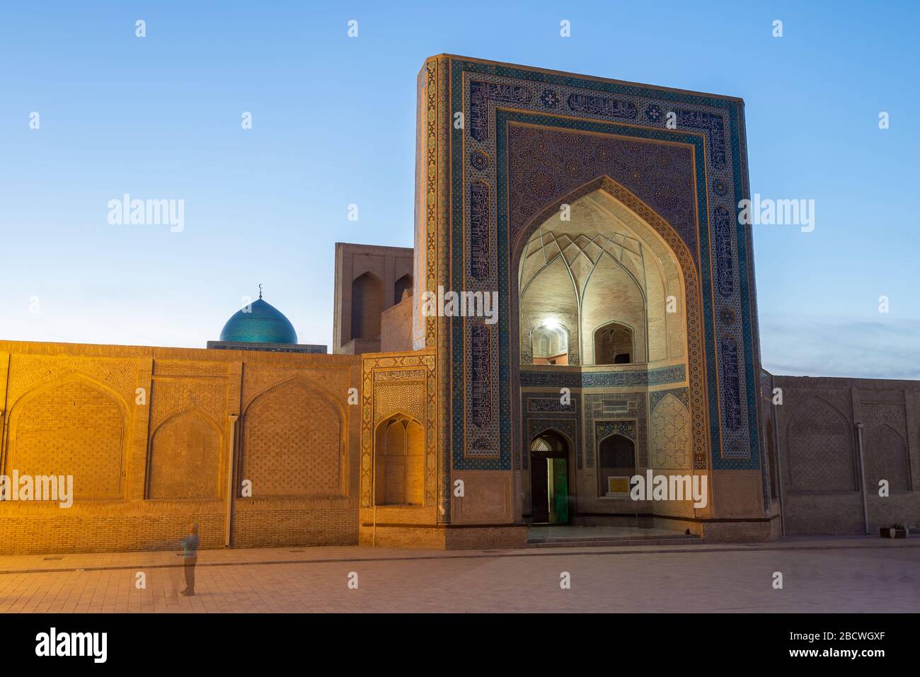 Fassade der Kalan-Moschee am Po-i-Kalan Religiösen Komplex in Buchara, Usbekistan während der blauen Stunde. Moschee iwan dekoriert im POI Kalan. Kalon Moschee. Stockfoto