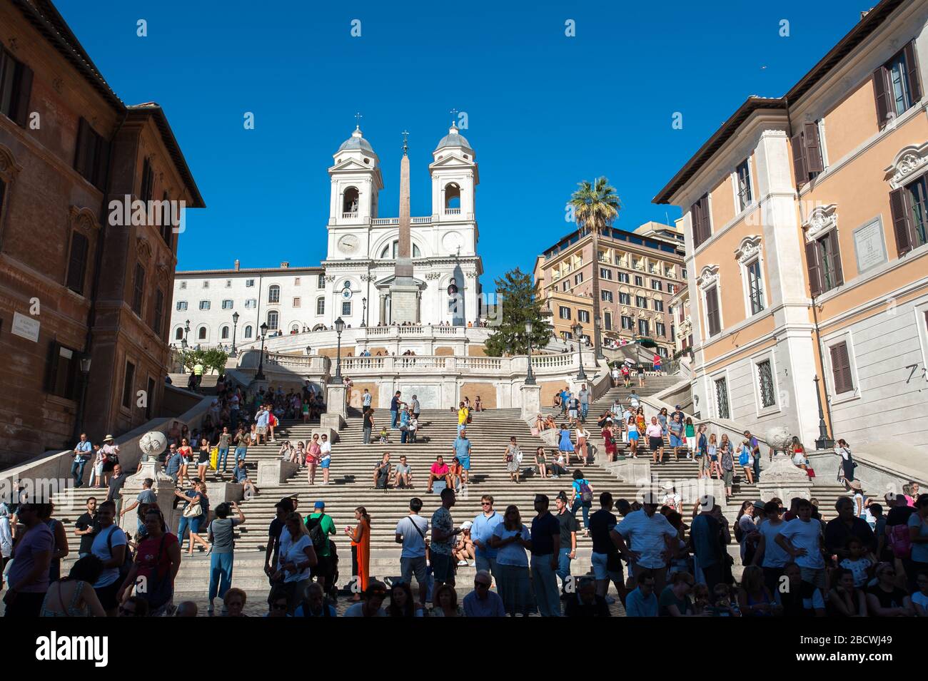 ROM, ITALIEN - 1. JULI 2017 - geschäftige Tage auf der spanischen Treppe, Rom, mit der Kirche Trinità dei Monti, die von oben auf die Menschenmassen blickt. Stockfoto