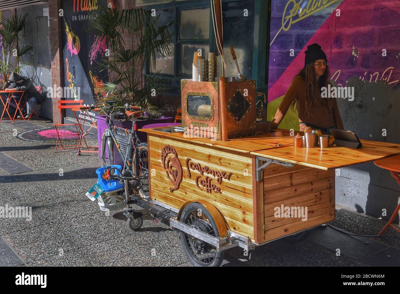 Vancouver, Kanada - 4. März 2020: Diana Lupieri Miteigentümerin des mobilen Wagens mit einer Steampunk-Espressomaschine, die an einem Fahrrad auf Granv befestigt ist Stockfoto