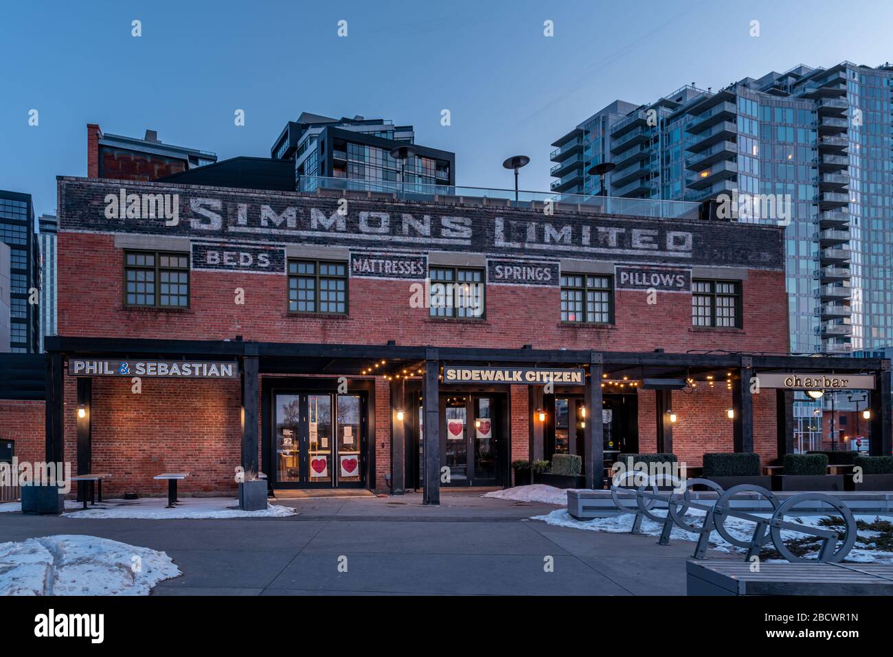 Calgary, Alberta - 4. April 2020: Blick auf das Simmons Building am Abend. Viele hippe Geschäfte besetzen dieses Gebäude. Stockfoto