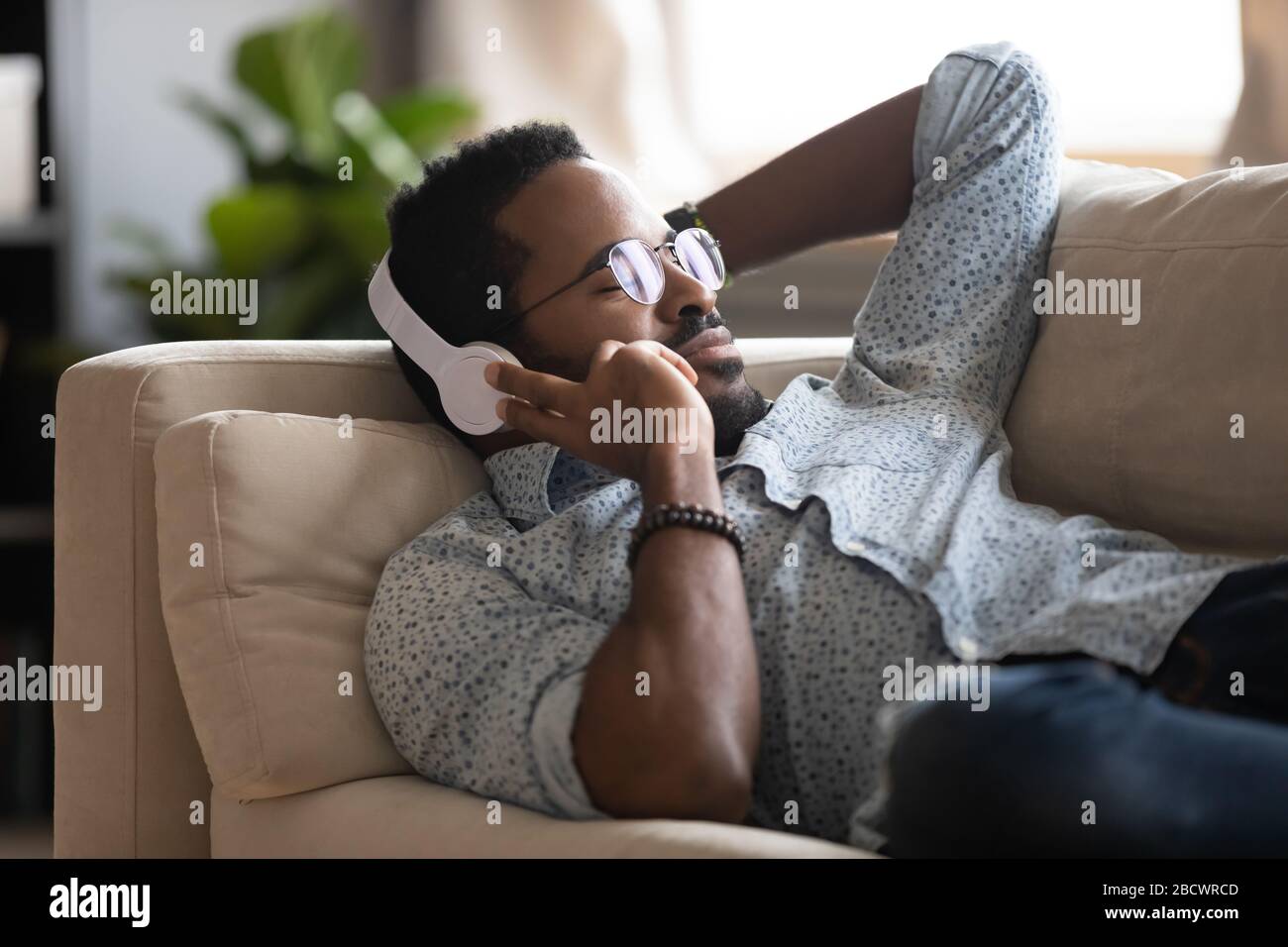 Afroamerikanischer Mann genießen Sie Musik in kabellosen Kopfhörern Stockfoto