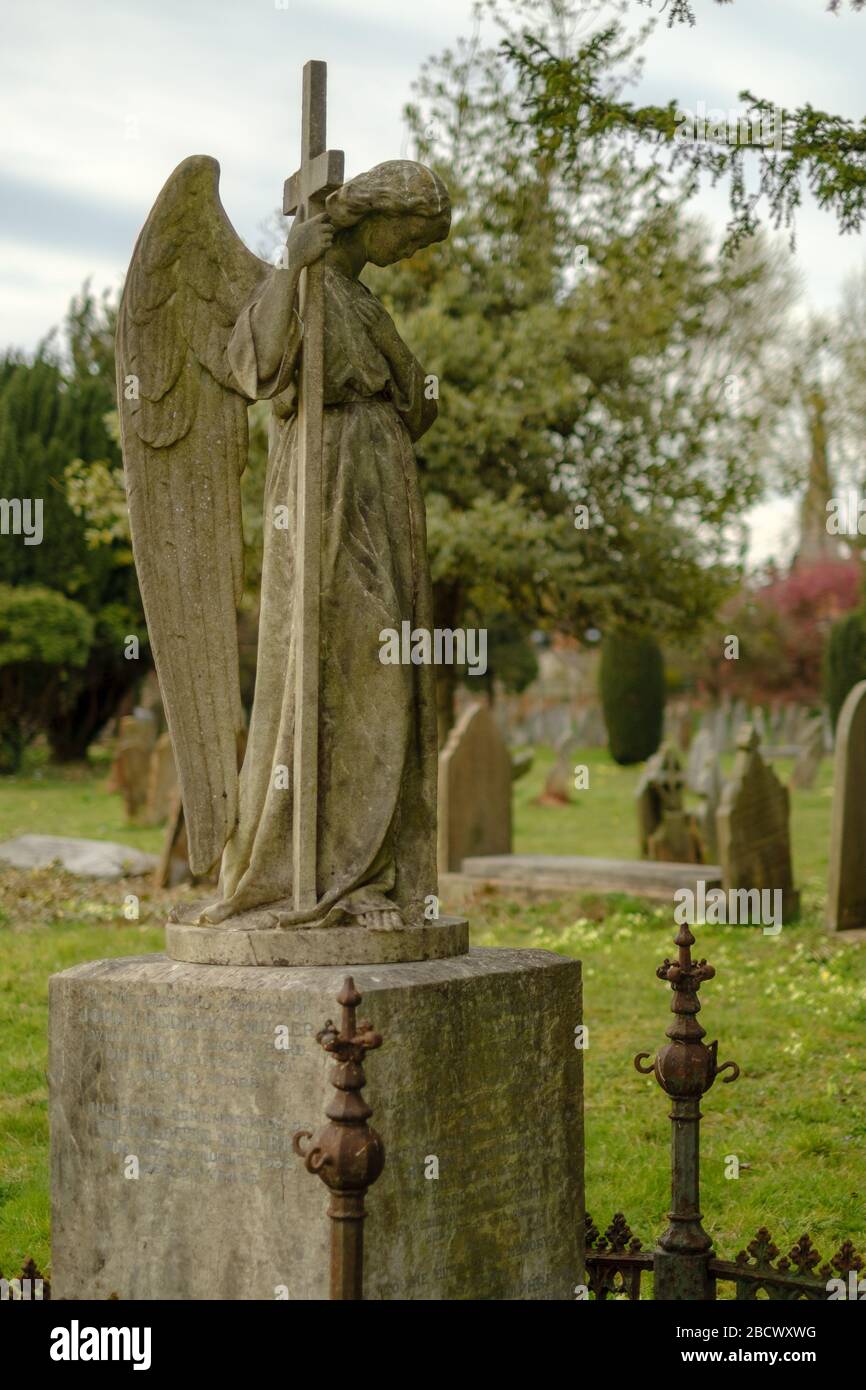 Grabsteinstatue eines Engels mit einem Kreuz. Stockfoto