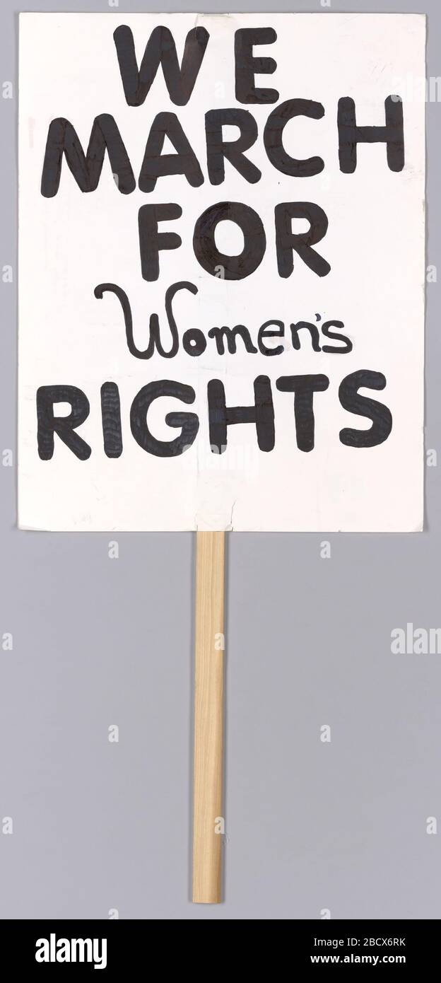 Requisit von Dance Recital Performance Dance to Glory von Studio A. dieses Pappschild ist ein rechteckiges Stück Pappe mit handgeschriebenem Text in schwarzer Markierung. Der Text lautet "wir/ März/ für/ Frauen/Rechte". Hinten ist ein schmaler flacher Holzstab mit Klebstoff als Griff montiert. Die Rückseite ist leer. Vom Tanzdarbietung Tanz zum Ruhm von Studio A Stockfoto