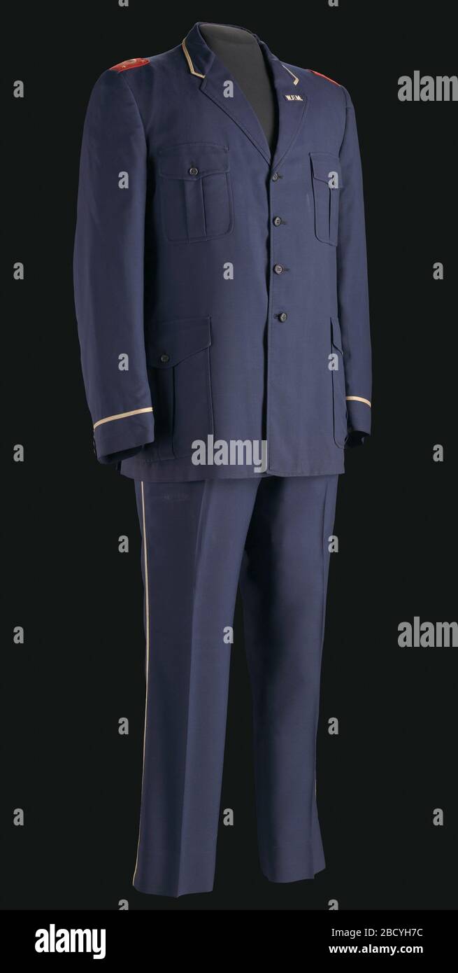 Frucht der Islam-Uniform. Marineblaues Anzug (männlich) mit weißen geflochtenen Streifen an Hosen und Oberteil der Jacke; rot-weißes Logo der Nation of Islam oben auf den Schultern; marineblaue Kappe mit schwarzem Lackleder Frucht der Islam-Uniform Stockfoto