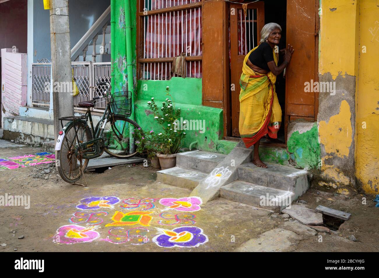 Ältere Frauen gehen langsam die Stufen vor ihrem Haus, Tiruchendur, Indien, hinunter Stockfoto
