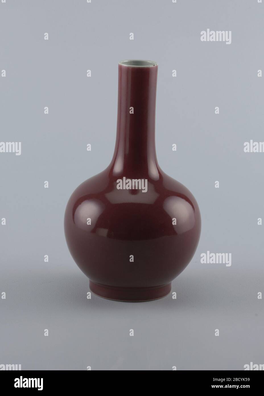 Vase. Forschung in ProgressBottle-Form: Kugel, mit geradem, schlangenem Hals, kurzer Fuß. Beschichtet von weißem Rand zu Fuß mit monochromer Oxblood Farbglasur von Birnhauttextur. Vase Stockfoto