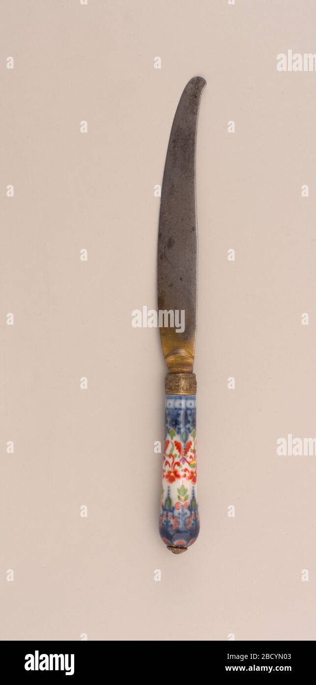 Messer mit Porzellangriff. Forschung in ProgressSabre-förmigem Rotorblatt, Tropfenpolster. Mit Tieren und Blumen eingravierte Ferrule, vergoldete Ferrule und Bolster. Porzellangriff verjüngt, im Schnitt rund. Blumenmuster in blau, rot, grün, gelb und violett auf weißem Grund. Knopfverschluss oben am Griff. Messer mit Porzellangriff Stockfoto