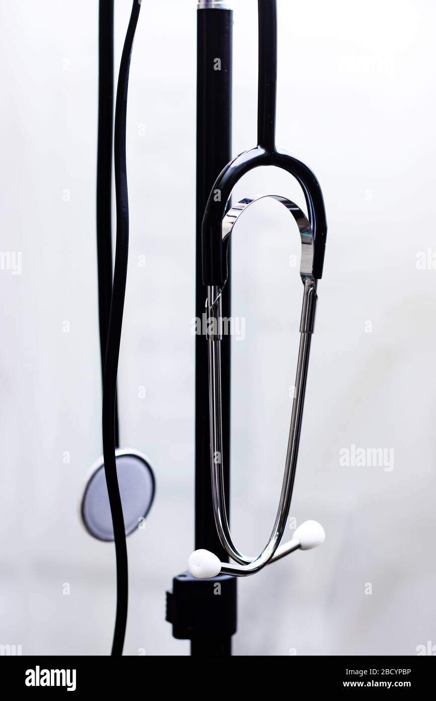 Stethoskop, das auf einem schwarzen Standfuß auf weißem Hintergrund hängt Stockfoto