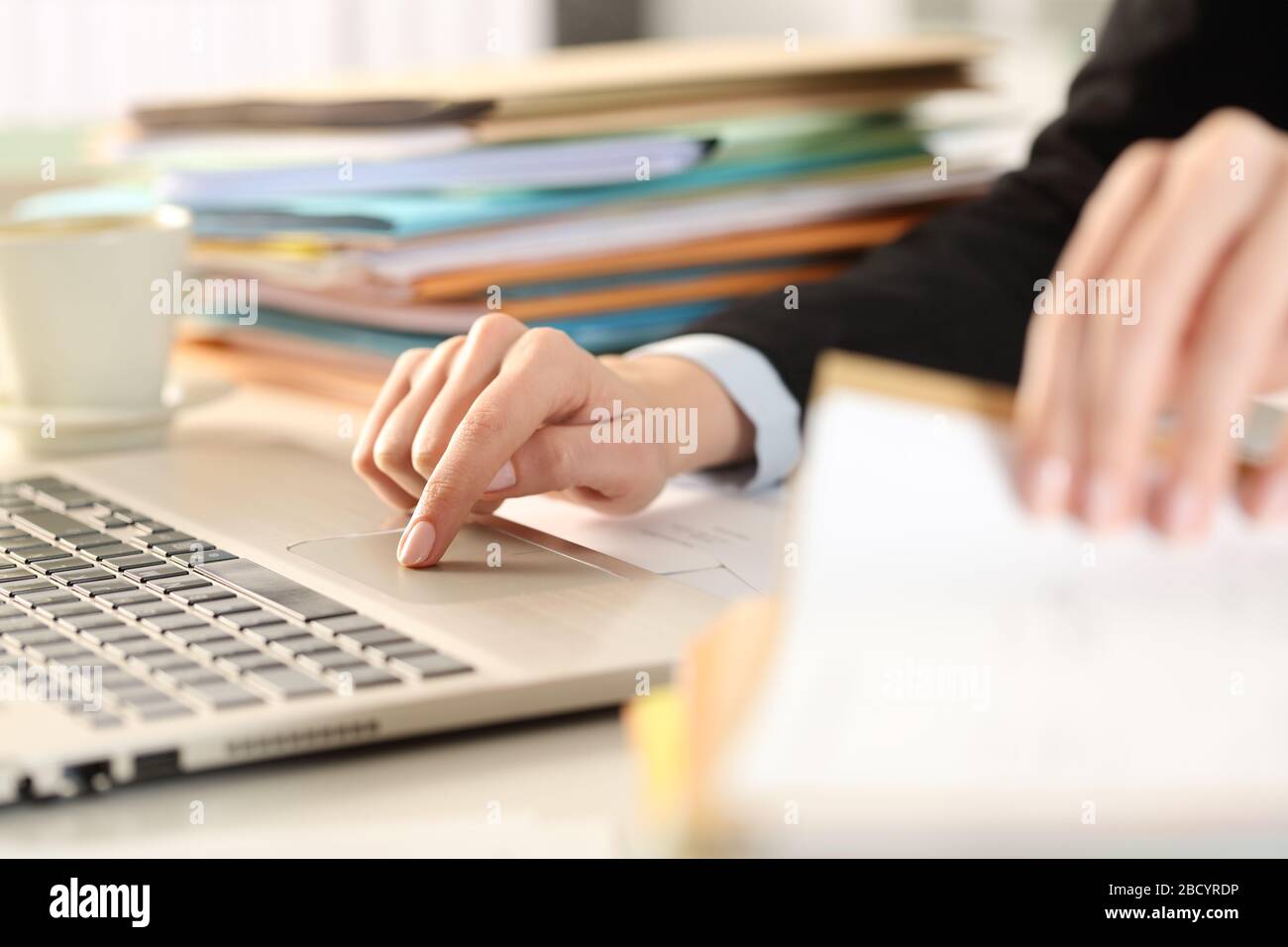 Nahaufnahme der überarbeiteten Führungskraft übergibt die Dokumente mit einem Laptop auf einem Schreibtisch im Büro Stockfoto