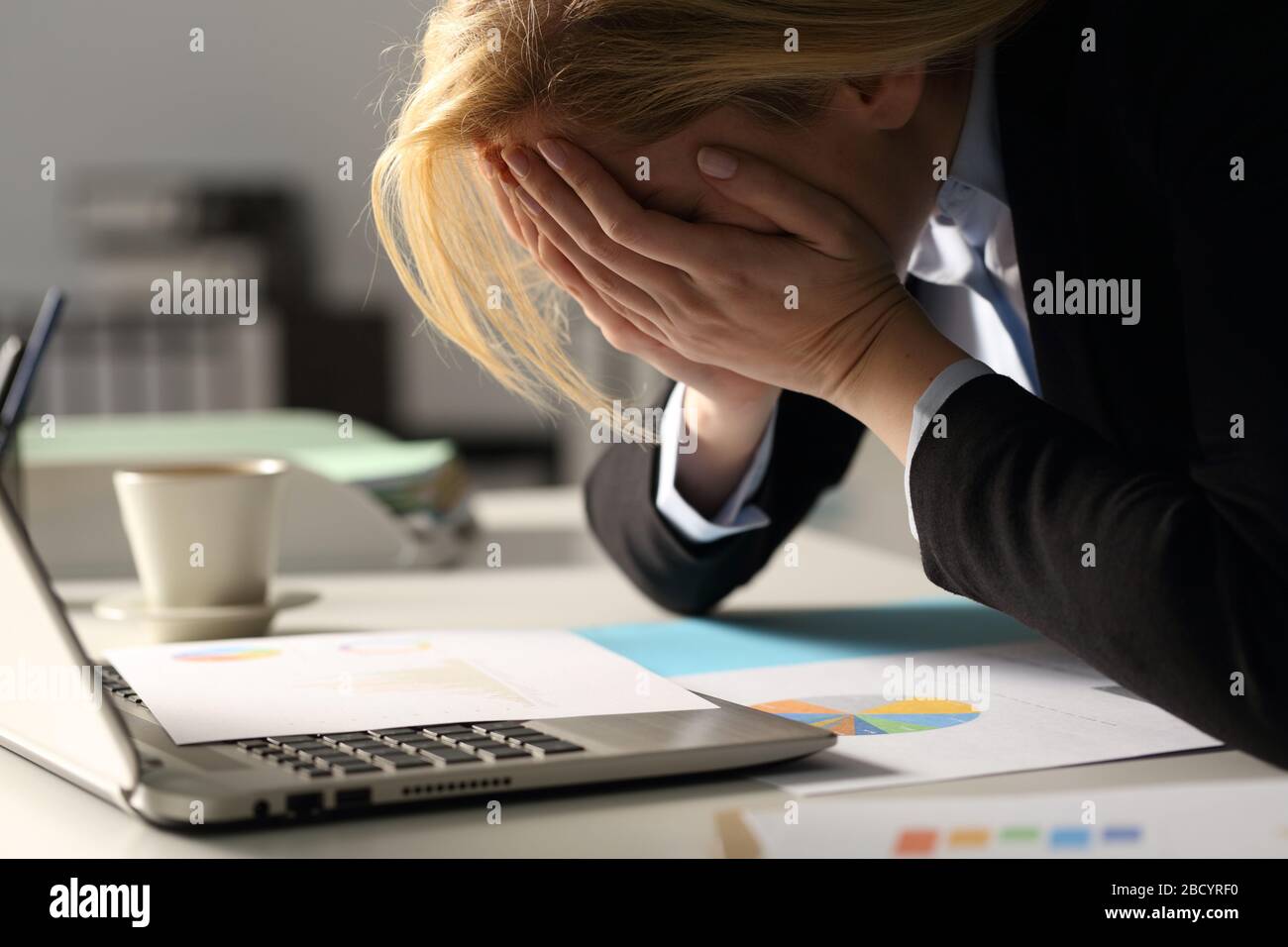 Nahaufnahme der traurigen Geschäftsführerin, die sich nachts im Büro über schlechte Ergebnisse beschwert Stockfoto