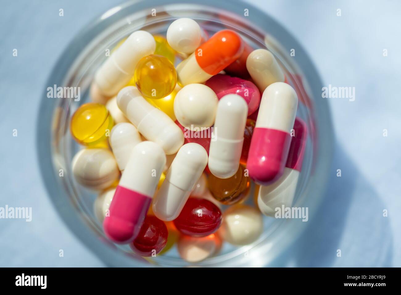 Verschiedene pharmazeutische Medikamente, Tabletten und Kapseln auf dem Glastisch Stockfoto