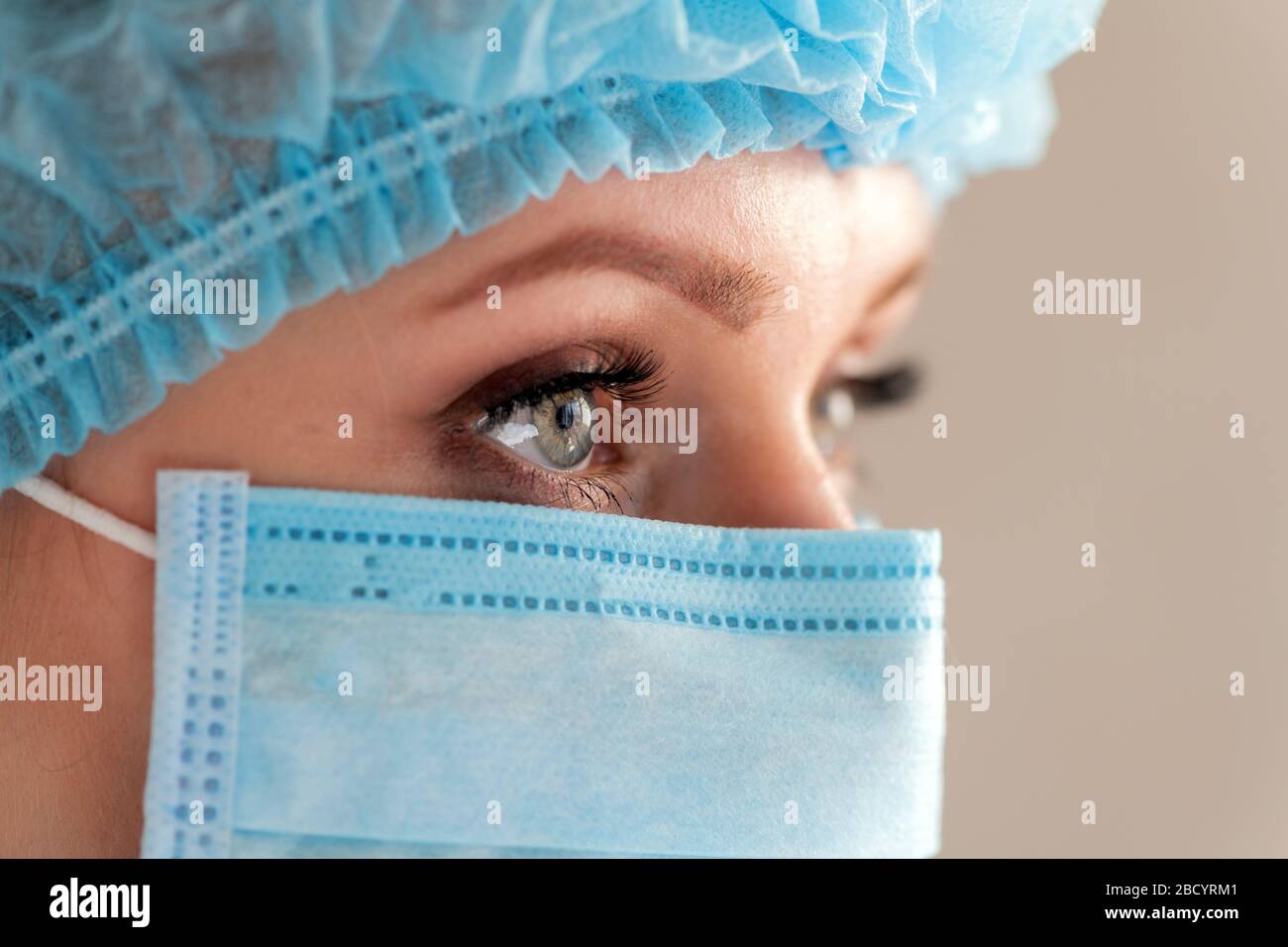 OP-Pfleger oder Arzt mit Gesichtsmaske und Kappe. Gesundheitswesen, Chirurgie. Nahaufnahme des Porträts junger kaukasischer Frauen Stockfoto