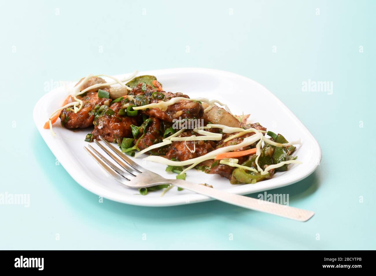 Chili Paneer oder würziger Hüttenkäse, Garnierung mit Capsicum, Zwiebel, Kohl und Frühlingszwiebel, beliebtes indisches Startermenü, in weißem Gericht serviert Stockfoto