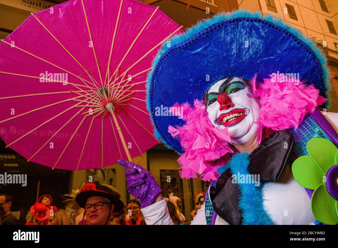 Eine Frau, verkleidet und als Clown bemalt, feiert tagsüber auf den Straßen den Karneval Stockfoto