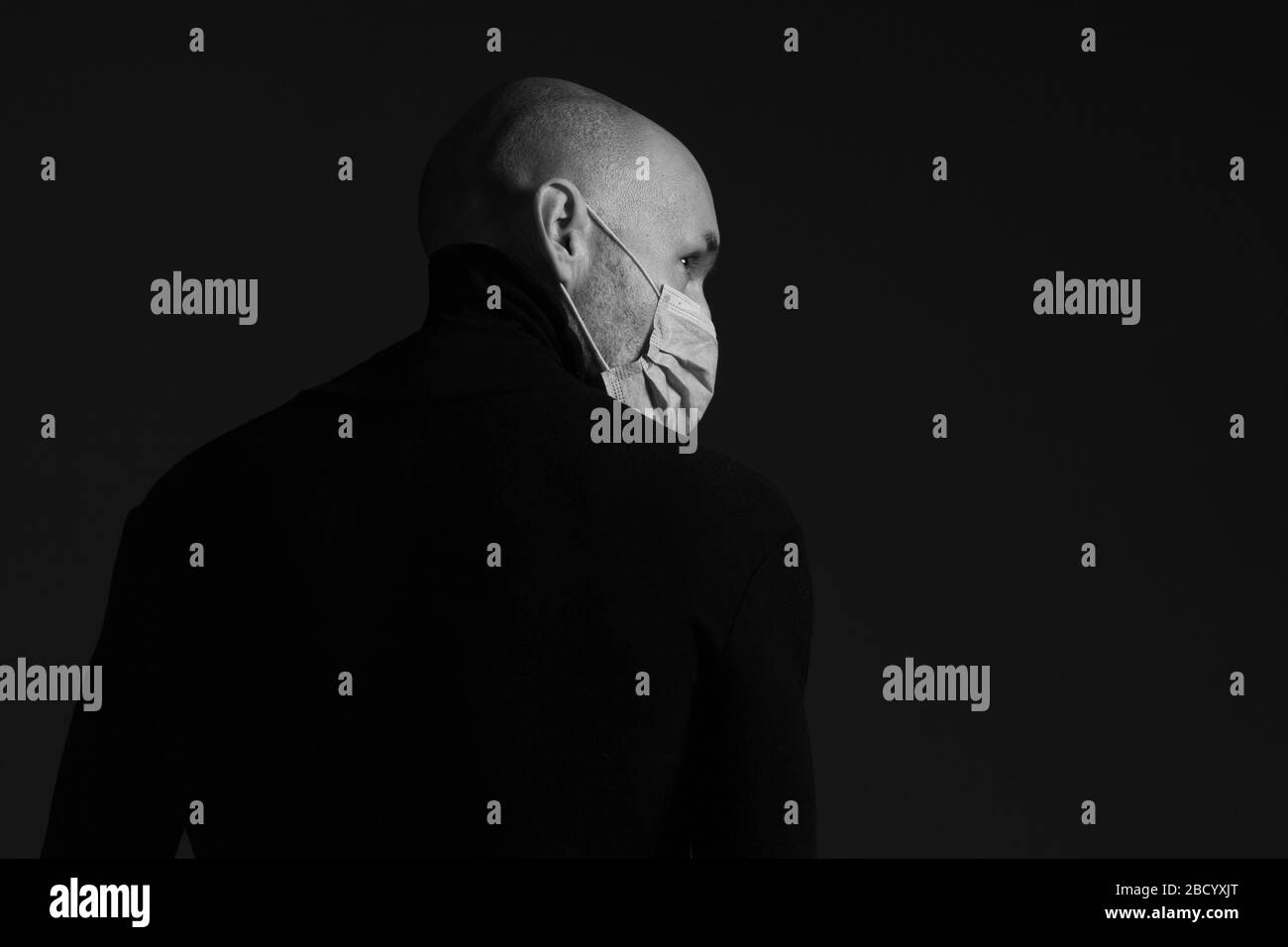 Coronavirus, Bio-Schutz-Konzept. Nahaufnahme Porträt von gutaussehenden kahlen Mann mit medizinischer Maske, schwarzem Rollkragen und Blick nach rechts mit Hoffnung. Stockfoto