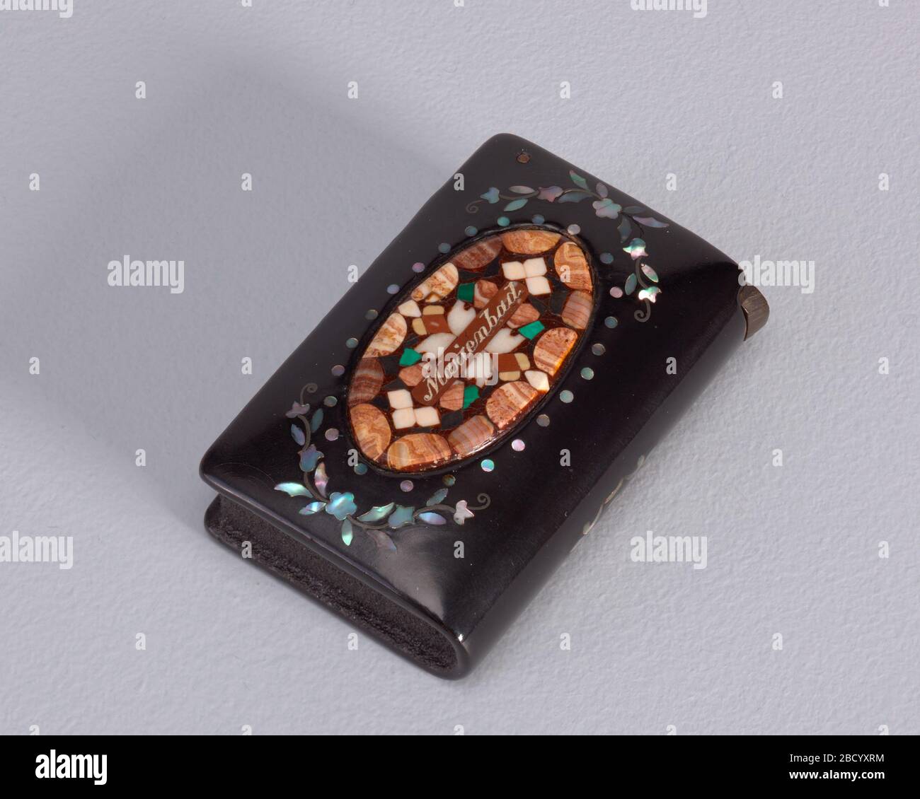 Marienbad. Forschung in ProgressRectangular, abgerundete Ecken, in Buchform, mit zentralem ovalem Reservat mit verschiedenen eingelegten Steinen, horizontal 'Marienbad' beschriftet; Reserve gerahmt von Perlmutt-Blumenschmuck; Buchrücken oder Unterseite mit Perlmutt-Dekorativ Marienbad verschönert Stockfoto