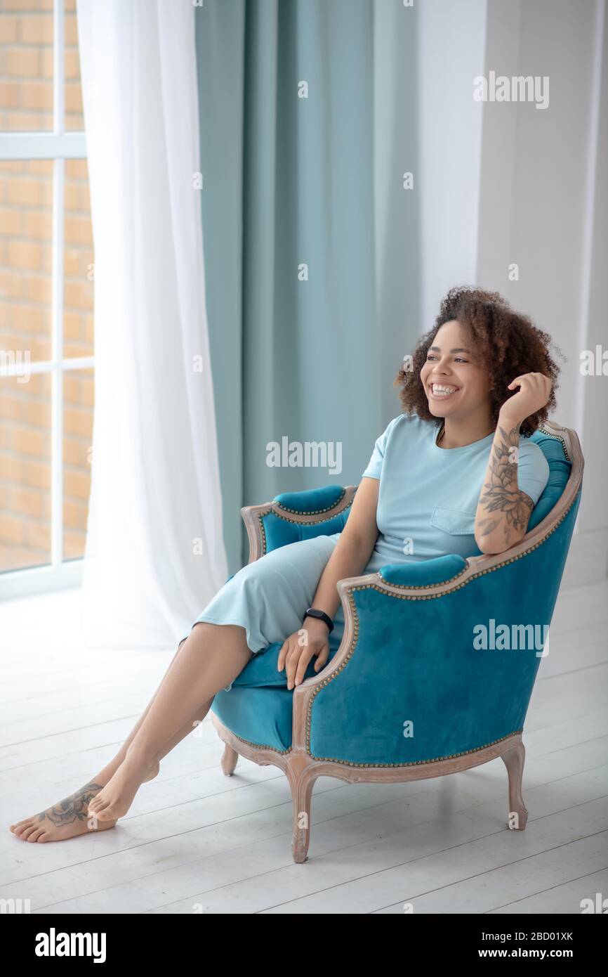 Stilvoll hübsche Frau mit Tätowierungen, die in einem Stuhl sitzen. Stockfoto